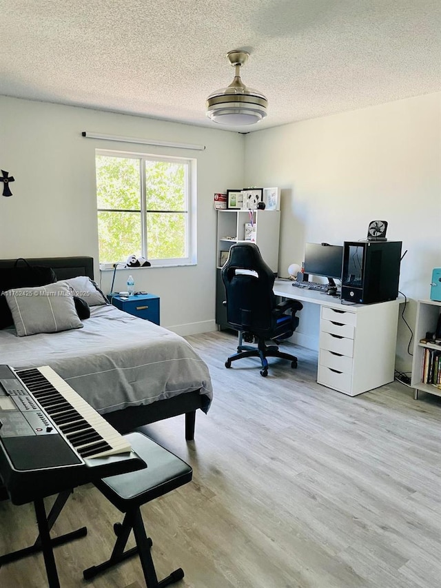 bedroom featuring light wood finished floors and a textured ceiling