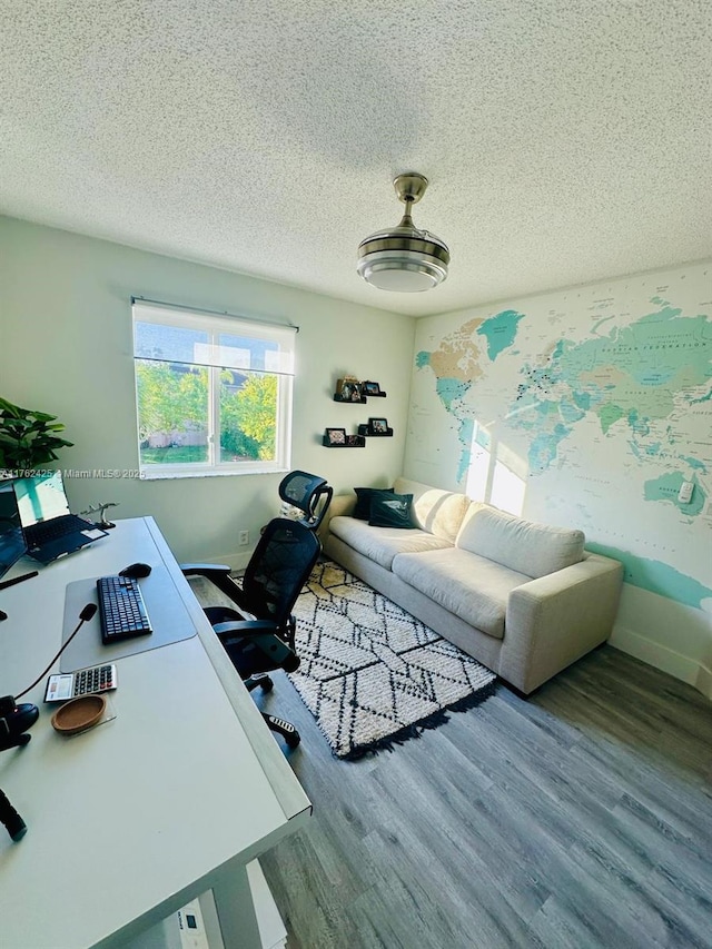 office with wood finished floors, baseboards, and a textured ceiling