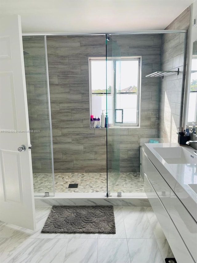 full bath featuring marble finish floor, a stall shower, and vanity