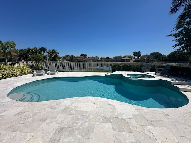 view of swimming pool with a fenced backyard, a pool with connected hot tub, and a patio