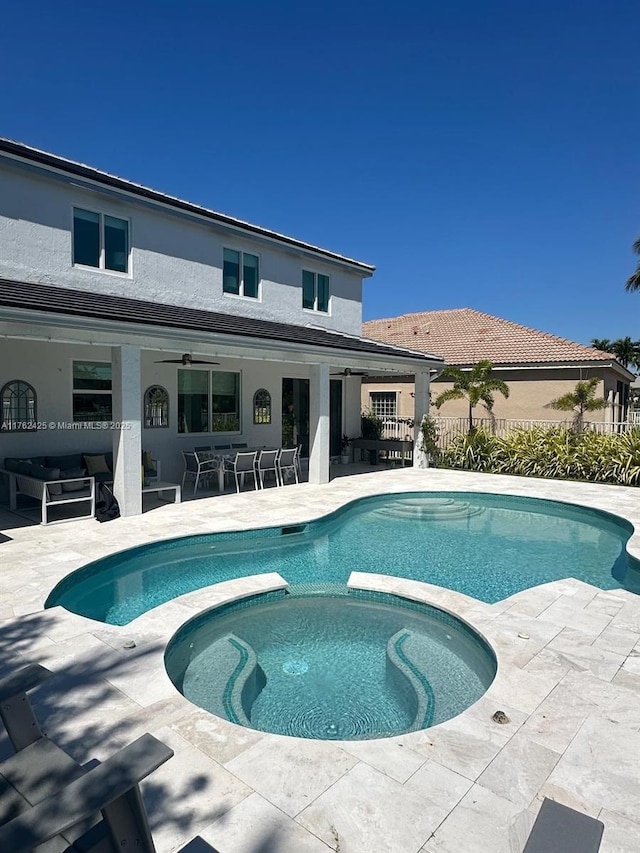 view of pool with outdoor dining space, a patio, fence, a pool with connected hot tub, and an outdoor hangout area