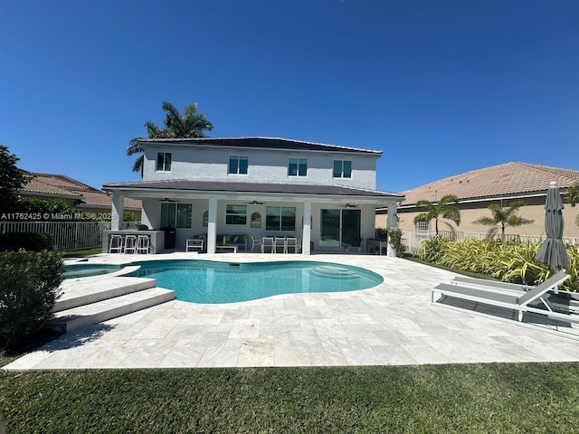 back of house featuring stucco siding, outdoor dry bar, a fenced backyard, a fenced in pool, and a patio area