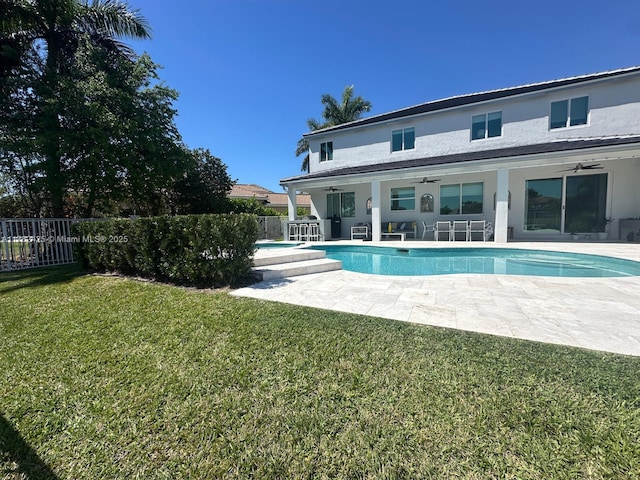 view of pool featuring a lawn, a ceiling fan, fence, a fenced in pool, and a patio area