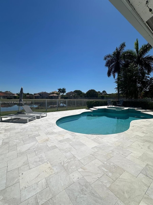 view of pool featuring a pool with connected hot tub, a patio, and fence