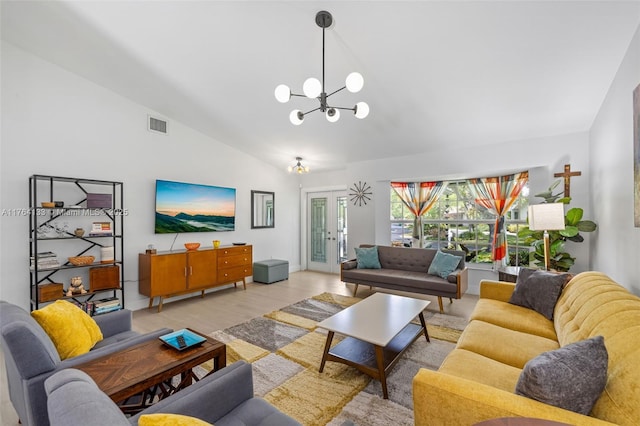 living area with lofted ceiling, light wood-type flooring, visible vents, and a chandelier