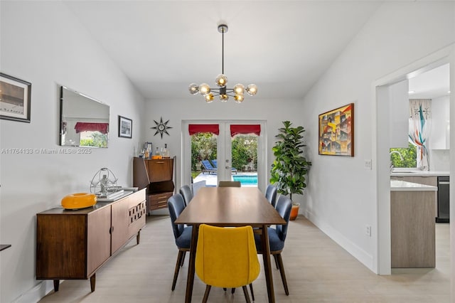 14130 SW 145th Ter, Miami, FL 33186 - dining room with baseboards, french doors, an inviting chandelier, and light wood finished floors