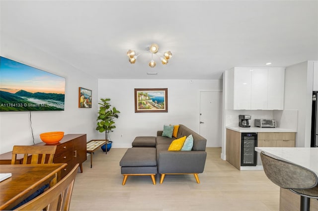 living area with visible vents, a toaster, beverage cooler, and light wood-style floors