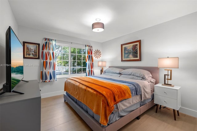 bedroom featuring baseboards and wood finished floors