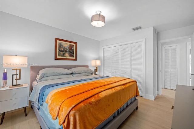 bedroom with visible vents, baseboards, a closet, and light wood-style flooring