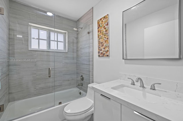 full bathroom with toilet, vanity, and bath / shower combo with glass door