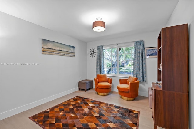 sitting room featuring light wood-type flooring and baseboards