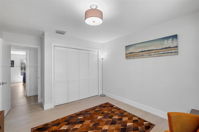 bedroom with visible vents, baseboards, a closet, and light wood-style flooring