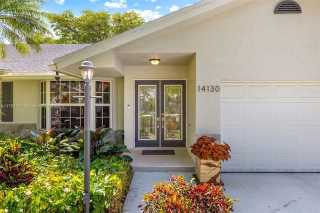 property entrance with stucco siding, a garage, and a shingled roof