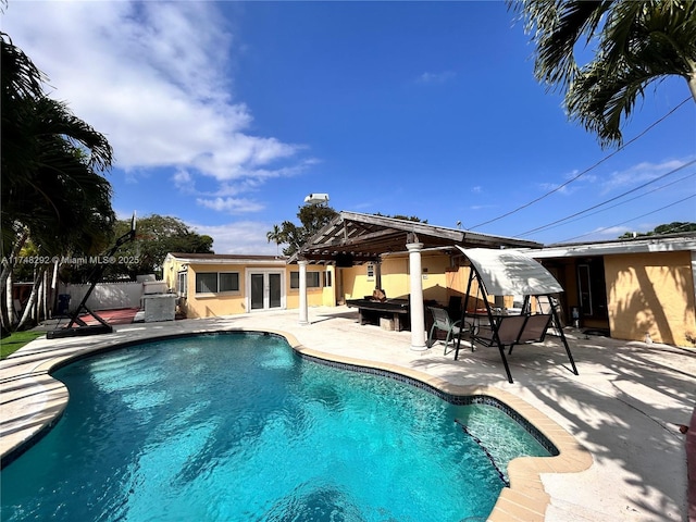 view of pool featuring a patio area, a fenced in pool, french doors, and fence