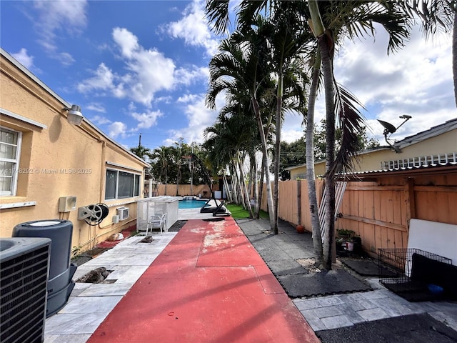 view of patio / terrace with central air condition unit, a fenced backyard, and a fenced in pool