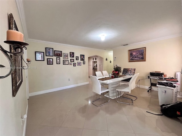 tiled dining room with baseboards, arched walkways, visible vents, and ornamental molding