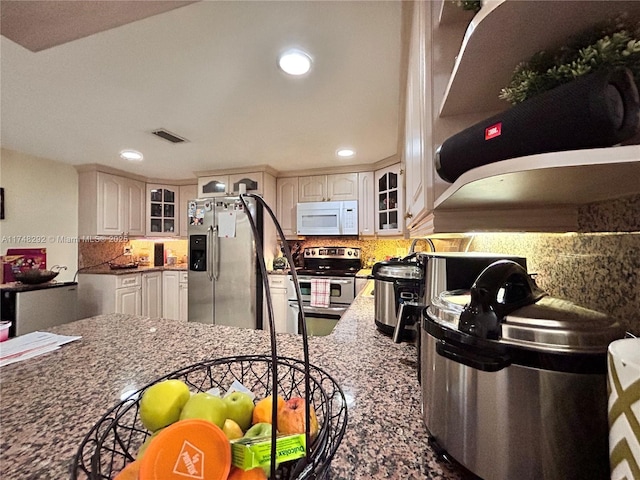 kitchen with visible vents, tasteful backsplash, recessed lighting, stainless steel appliances, and glass insert cabinets