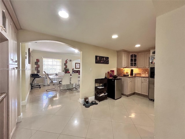 kitchen featuring light tile patterned floors, refrigerator, recessed lighting, arched walkways, and decorative backsplash