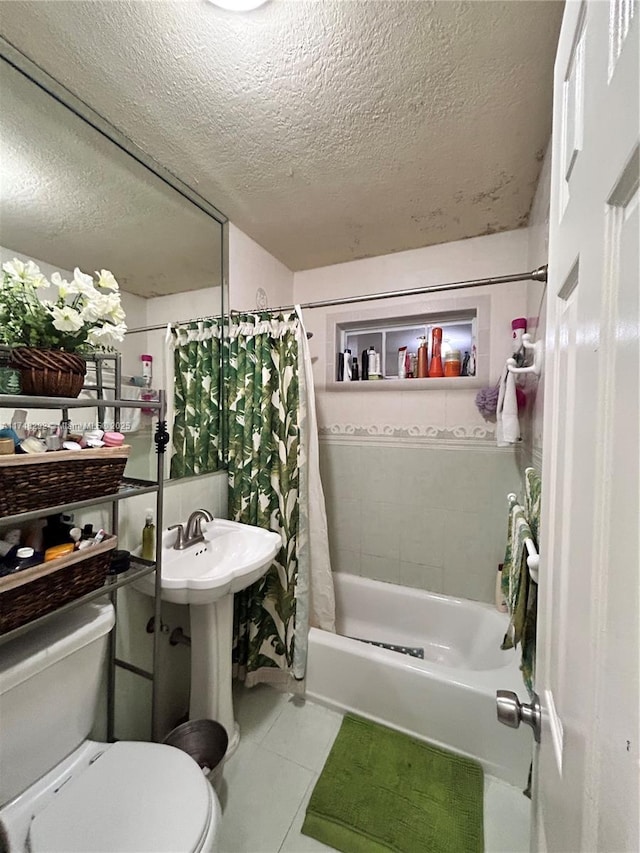 full bath featuring tile patterned floors, toilet, shower / bath combo, and a textured ceiling