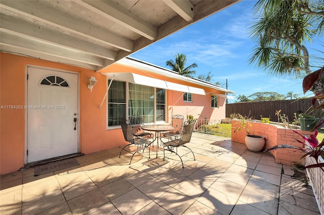 view of patio with outdoor dining space and fence