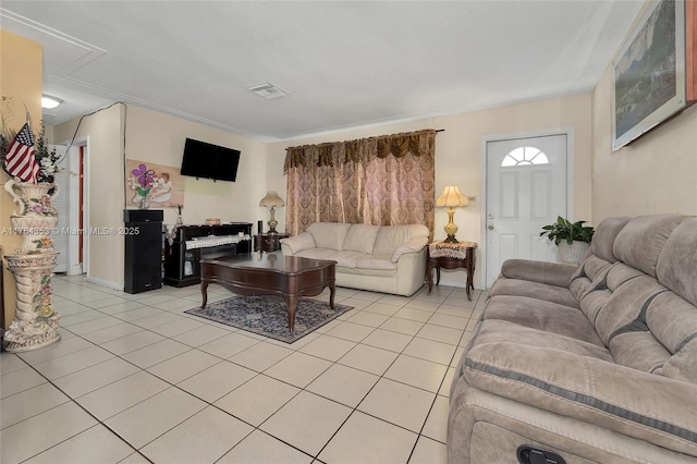 living area with attic access, light tile patterned floors, and visible vents