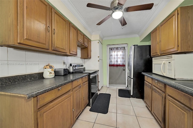 kitchen featuring stainless steel appliances, brown cabinets, dark countertops, and ornamental molding