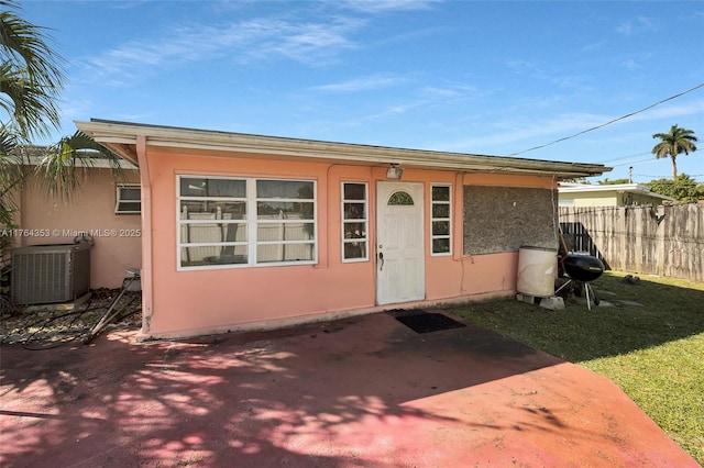 view of outbuilding with central air condition unit and fence