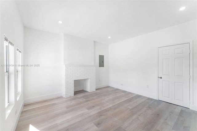 interior space featuring electric panel, recessed lighting, light wood-style flooring, and baseboards