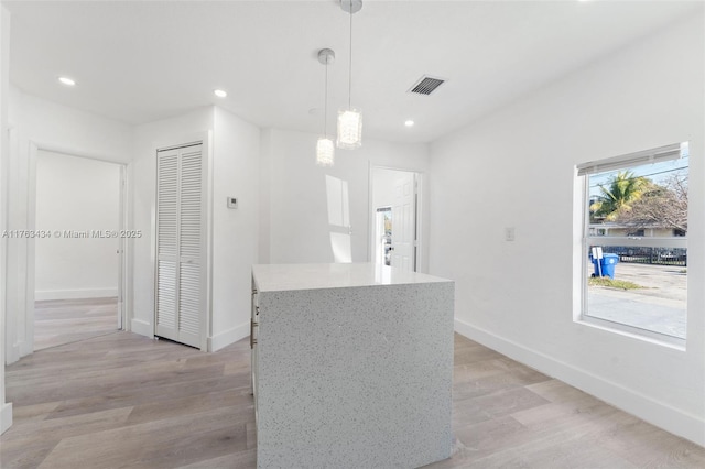 kitchen featuring decorative light fixtures, baseboards, light wood-style floors, and recessed lighting