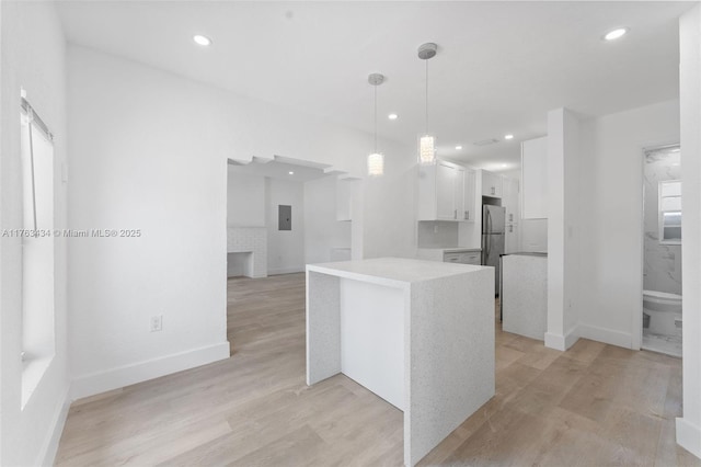 kitchen featuring light wood-style floors, white cabinets, light countertops, and freestanding refrigerator