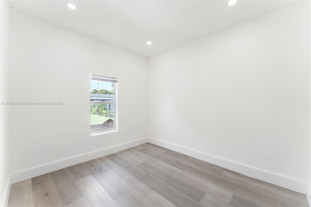 spare room featuring recessed lighting, light wood-type flooring, and baseboards