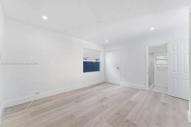 spare room featuring recessed lighting, light wood-style floors, and baseboards