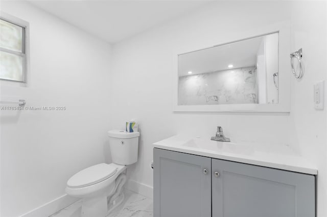 bathroom featuring baseboards, toilet, marble finish floor, and vanity