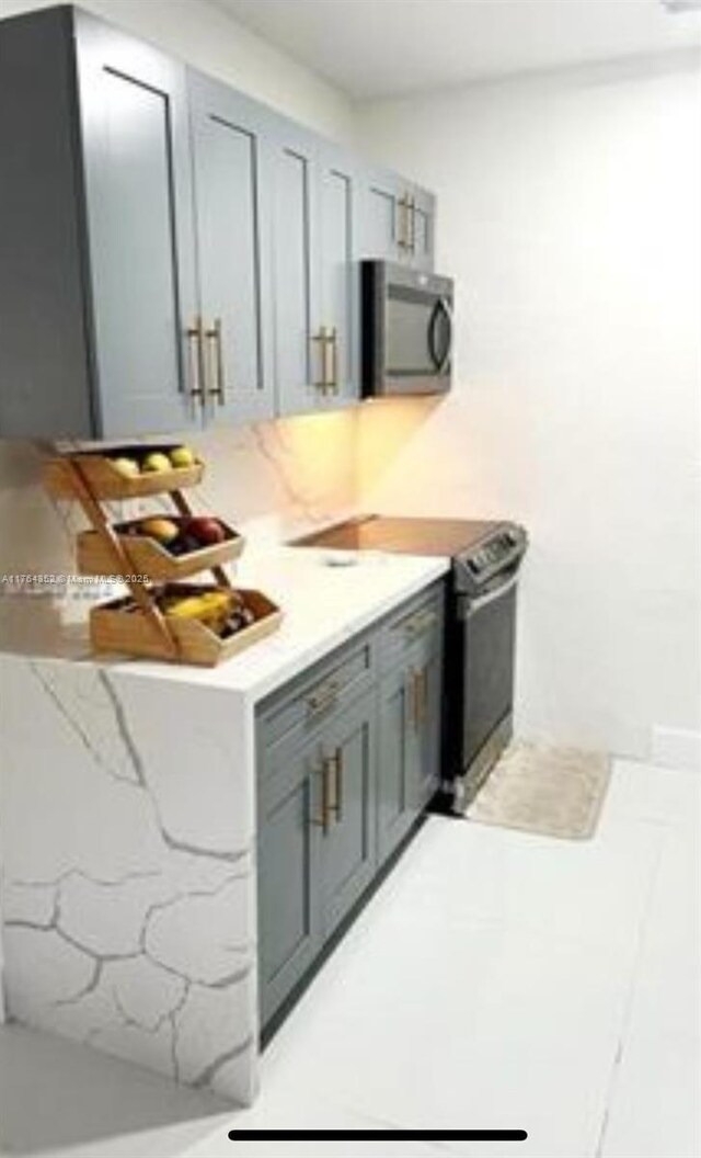 kitchen featuring stainless steel microwave, gray cabinets, and black electric range oven