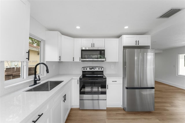 kitchen with a sink, stainless steel appliances, visible vents, and a healthy amount of sunlight