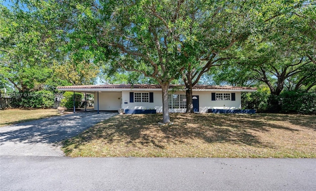 ranch-style house featuring a carport, stucco siding, and aphalt driveway