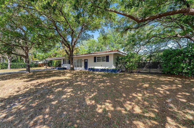 single story home featuring stucco siding, an attached carport, and fence