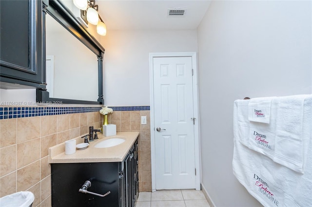 bathroom featuring tile patterned flooring, visible vents, tile walls, and vanity