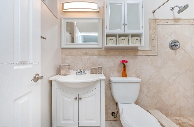 full bath with vanity, tile walls, toilet, and tiled shower