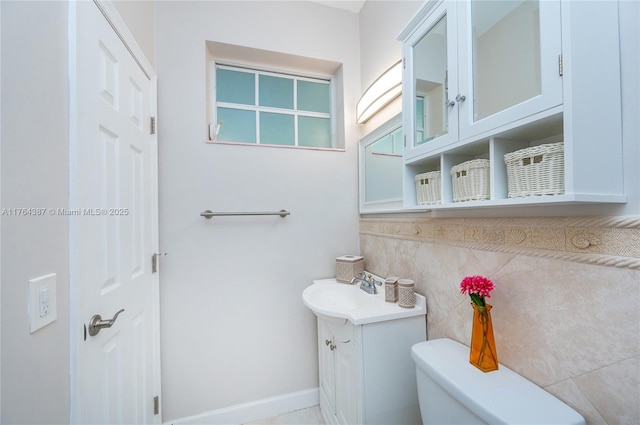 bathroom with vanity, toilet, and baseboards