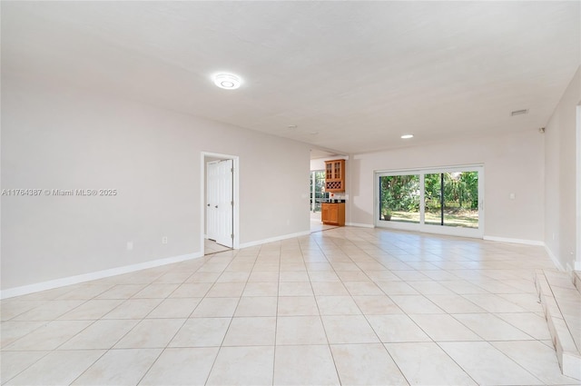 unfurnished room with light tile patterned floors and baseboards