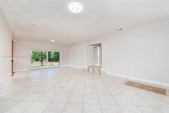 empty room with visible vents, baseboards, and light tile patterned flooring