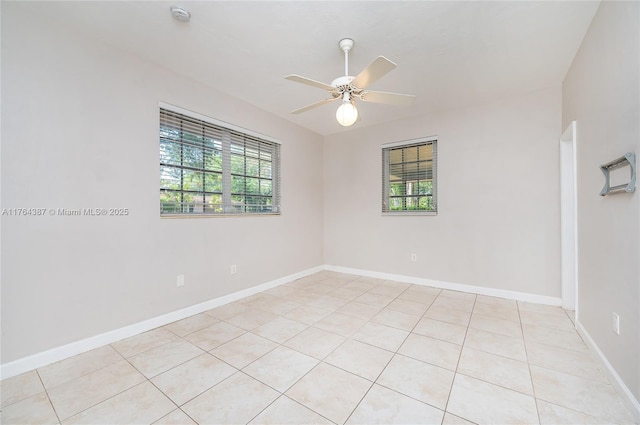 unfurnished room featuring a ceiling fan, light tile patterned flooring, a healthy amount of sunlight, and baseboards