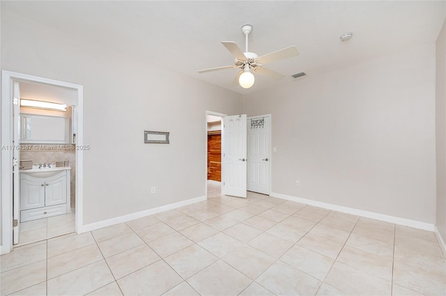 unfurnished bedroom featuring a sink, visible vents, baseboards, and light tile patterned flooring