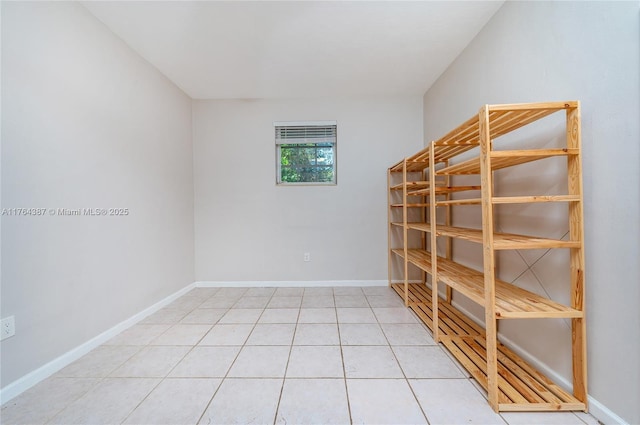 unfurnished room with baseboards and light tile patterned flooring