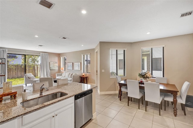 kitchen featuring visible vents, a healthy amount of sunlight, a sink, white cabinetry, and stainless steel dishwasher