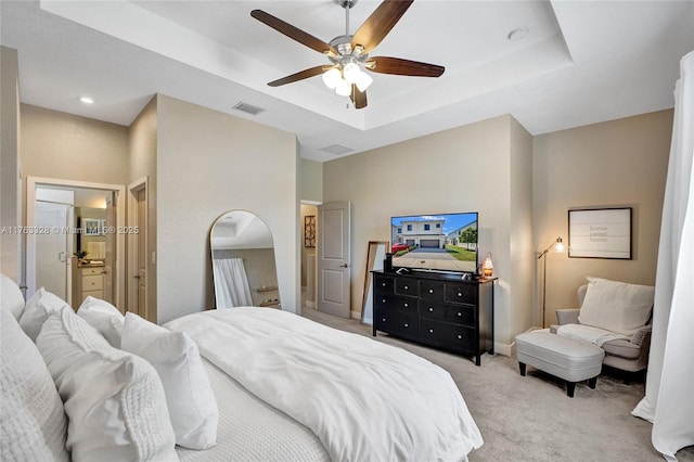 bedroom featuring visible vents, a raised ceiling, light colored carpet, and baseboards