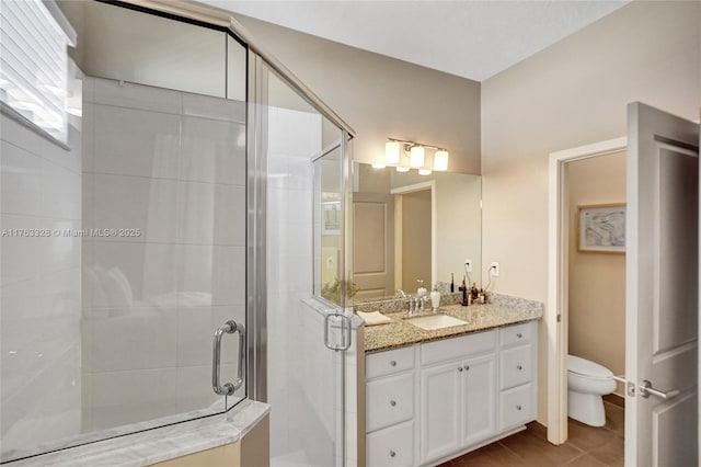 full bath featuring vanity, a shower stall, toilet, and tile patterned floors