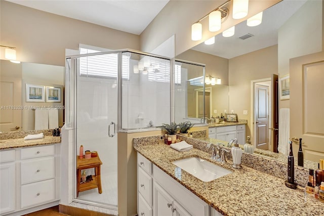 bathroom featuring vanity, visible vents, and a stall shower