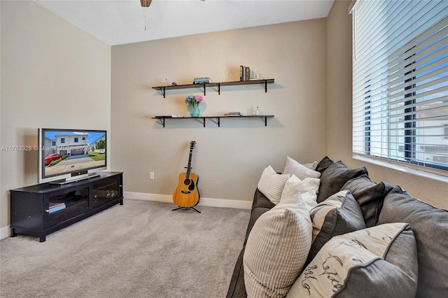 living room featuring baseboards, a ceiling fan, and carpet floors